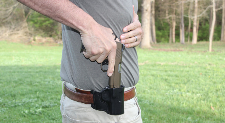 author demonstrates proper reholstering from strong-side hip position