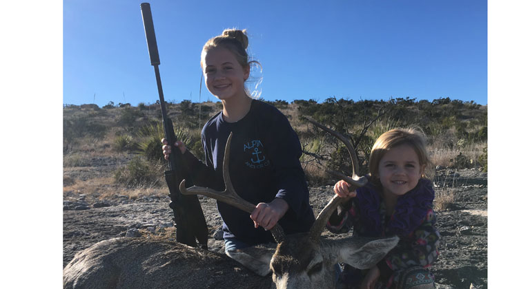 Author's daughters posing with their harvested mule deer