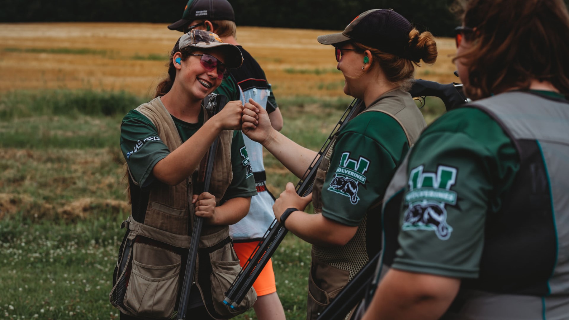 youth shotgun shooting team fist-bumping post game